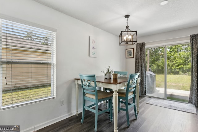 dining room with baseboards, a notable chandelier, and wood finished floors