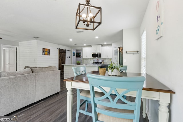 dining area with visible vents, a barn door, a chandelier, dark wood finished floors, and recessed lighting