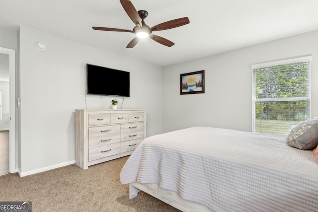bedroom featuring ceiling fan, light carpet, and baseboards