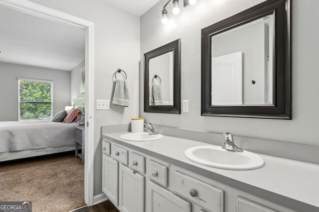 ensuite bathroom featuring a sink, double vanity, and connected bathroom