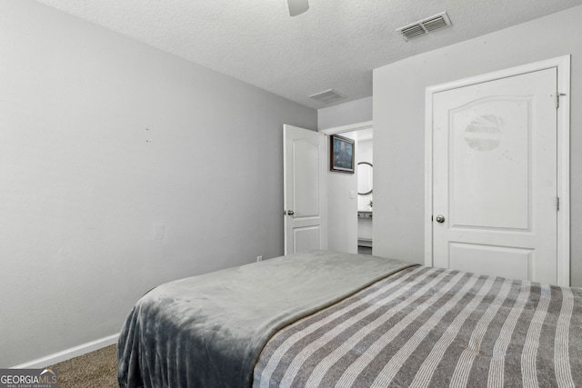 bedroom with carpet, visible vents, baseboards, and a textured ceiling