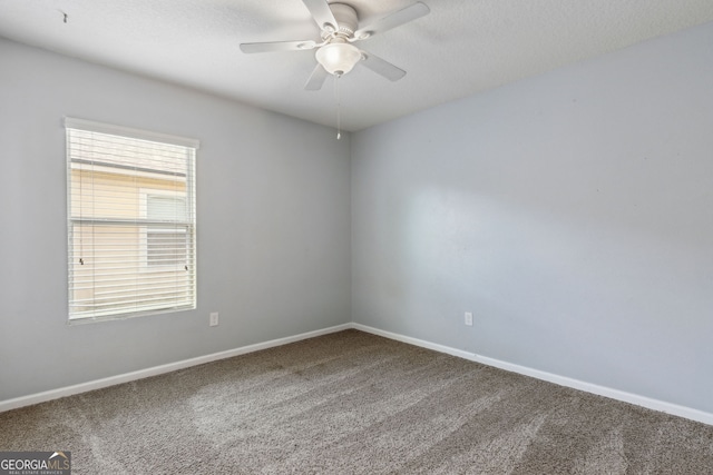 carpeted spare room featuring baseboards and ceiling fan