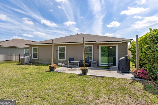 rear view of property featuring a patio area, a yard, fence, central air condition unit, and stucco siding