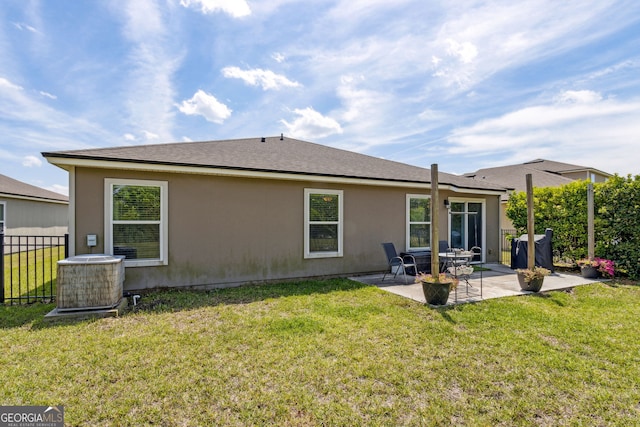 rear view of property featuring a patio, stucco siding, cooling unit, a yard, and fence