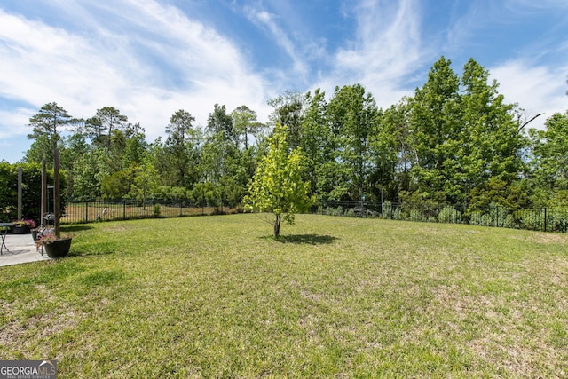 view of yard featuring fence and a patio
