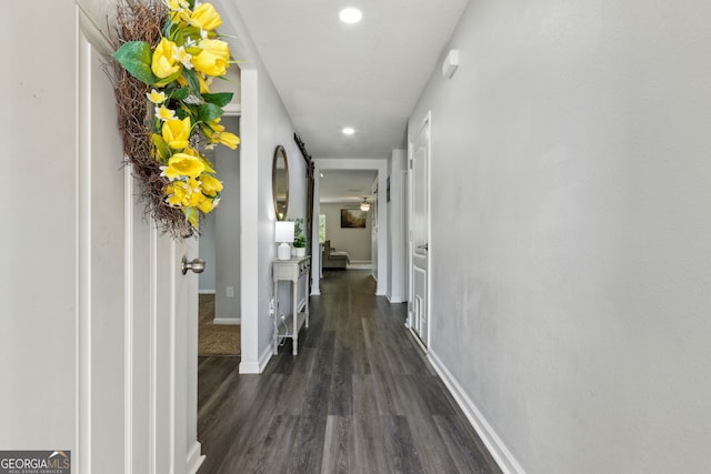 hall featuring baseboards, recessed lighting, and dark wood-style floors