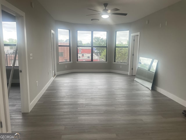 unfurnished room featuring baseboards, a ceiling fan, and plenty of natural light