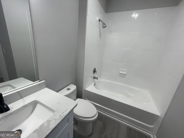 full bath with toilet, shower / bath combination, wood finished floors, and vanity