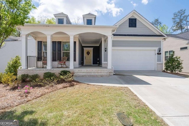 view of front of property featuring an attached garage, covered porch, concrete driveway, and brick siding