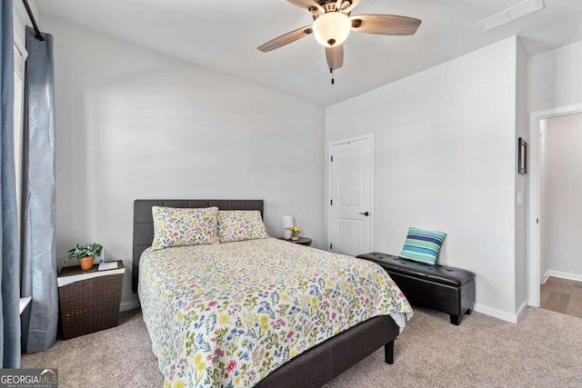 carpeted bedroom featuring lofted ceiling, visible vents, baseboards, and ceiling fan