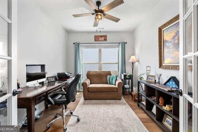 office space with visible vents, ceiling fan, and wood finished floors