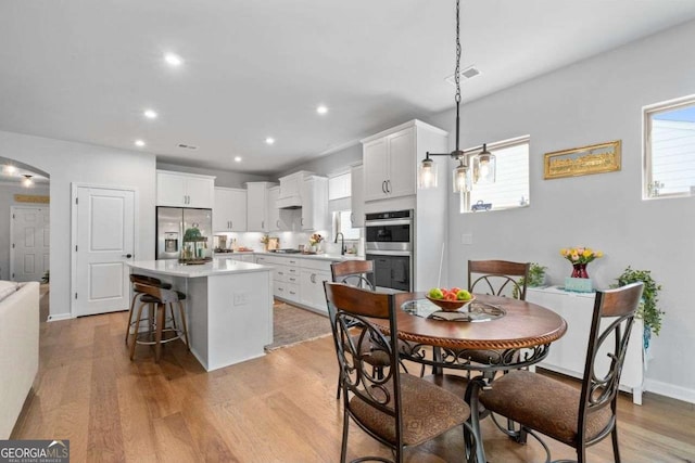dining area featuring light wood finished floors, baseboards, visible vents, and recessed lighting