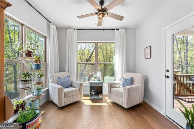 sitting room featuring wood finished floors, a ceiling fan, and a healthy amount of sunlight