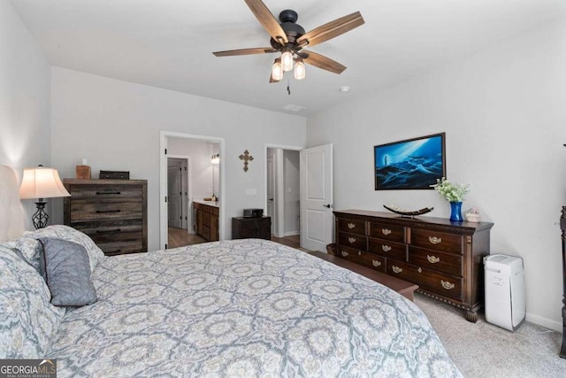 bedroom featuring baseboards, carpet, ceiling fan, and ensuite bath