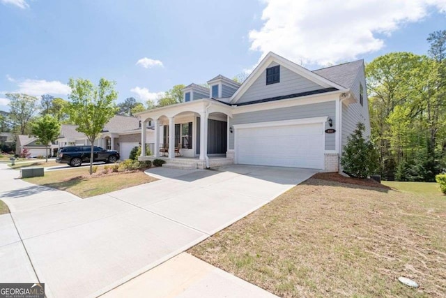 view of front of home with a garage, a porch, a front lawn, brick siding, and driveway