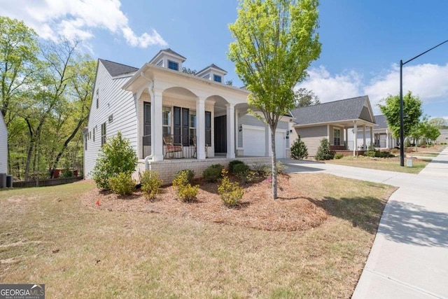 view of front of home featuring concrete driveway, a front lawn, an attached garage, a porch, and central AC unit