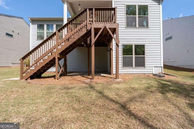 back of property with a lawn and stairway