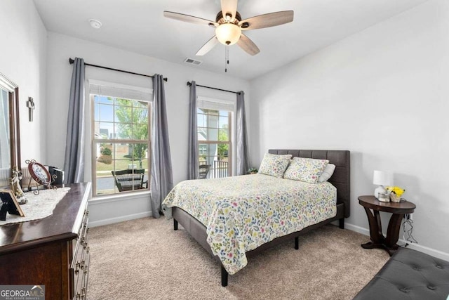 carpeted bedroom featuring visible vents, baseboards, and ceiling fan