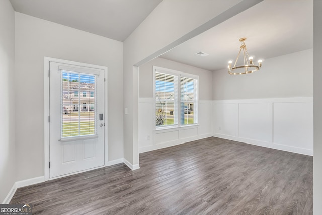 foyer featuring a wainscoted wall, a wealth of natural light, an inviting chandelier, and wood finished floors