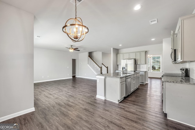 kitchen featuring stainless steel appliances, visible vents, baseboards, and light stone counters