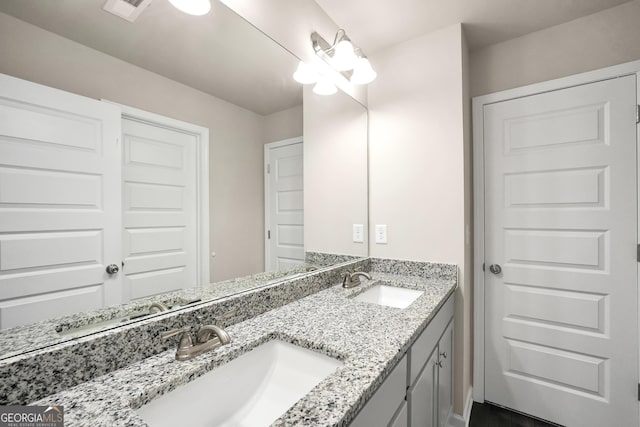 full bath featuring a sink, visible vents, and double vanity