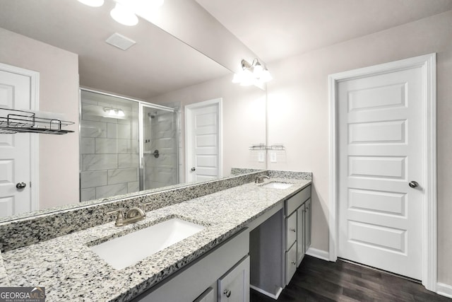 full bath featuring baseboards, a sink, a stall shower, and wood finished floors
