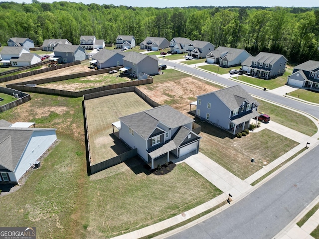 drone / aerial view featuring a residential view and a forest view