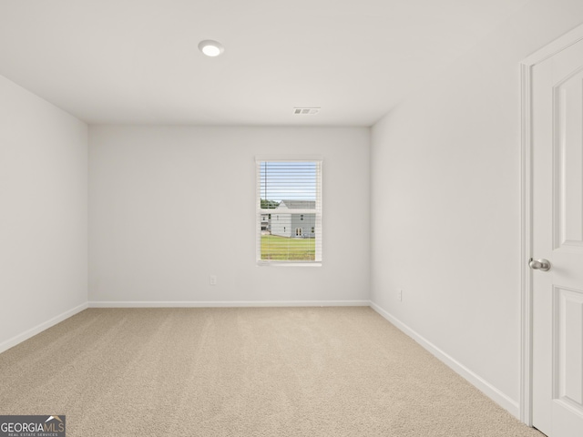 spare room with carpet flooring, baseboards, and visible vents