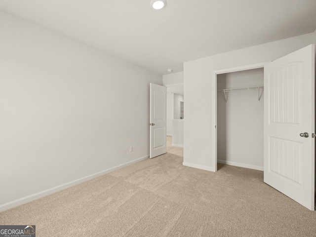 unfurnished bedroom with carpet floors, baseboards, and a closet