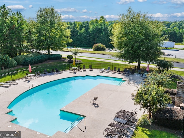 pool with a yard, a patio area, and fence