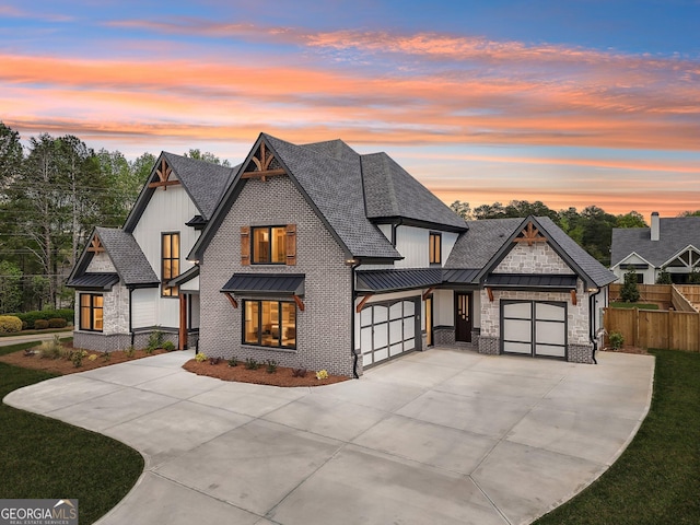 modern inspired farmhouse featuring concrete driveway, roof with shingles, a standing seam roof, metal roof, and fence