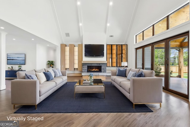 living area featuring visible vents, high vaulted ceiling, beam ceiling, and wood finished floors