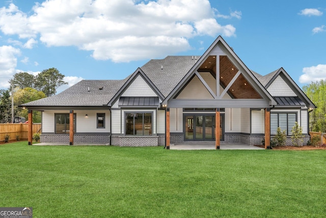 back of house with a standing seam roof, a patio, metal roof, and a yard