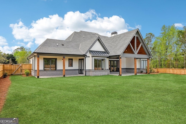 back of house with a patio, a shingled roof, a fenced backyard, and a lawn