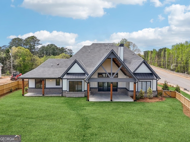 back of house featuring a standing seam roof, a patio area, metal roof, and a lawn