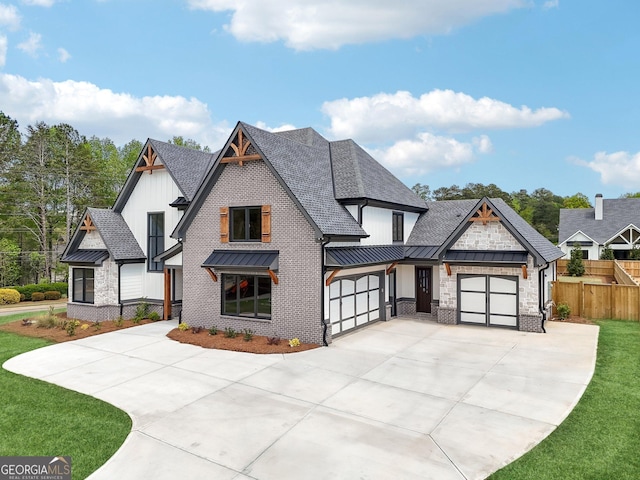 modern farmhouse featuring concrete driveway, a standing seam roof, metal roof, fence, and a shingled roof