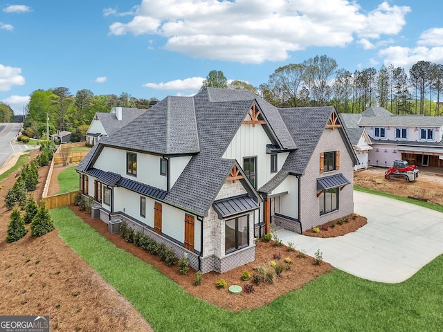 rear view of property featuring driveway, board and batten siding, a shingled roof, and central AC