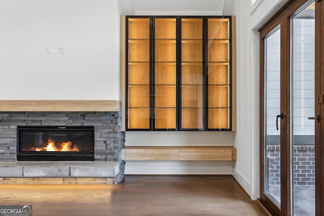 details with a fireplace, baseboards, and wood finished floors