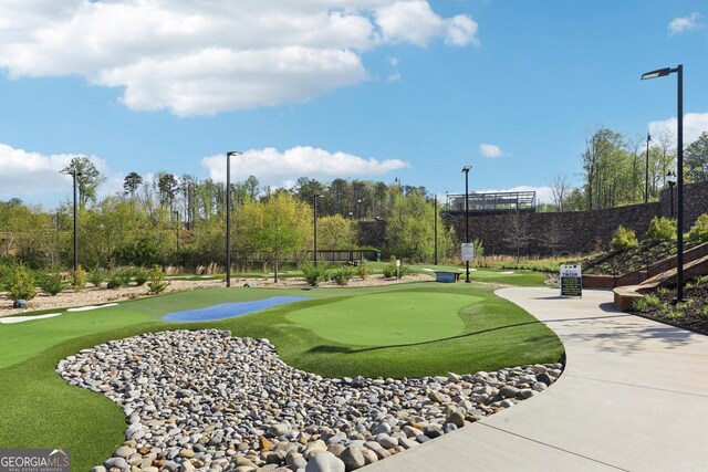 view of community featuring view of golf course and fence