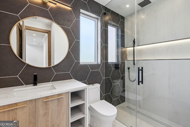 full bath featuring a shower stall, vanity, tile walls, and toilet