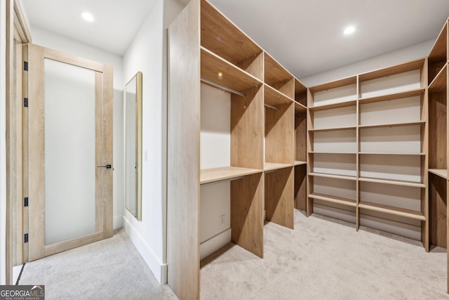 walk in closet featuring light carpet