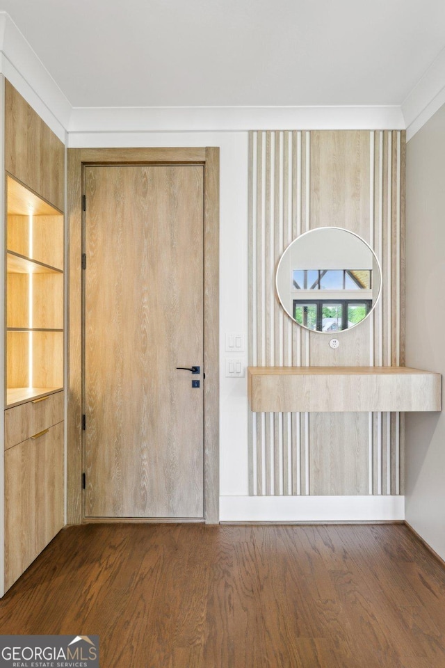 foyer featuring wood finished floors and ornamental molding