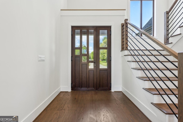 foyer entrance featuring stairway, dark wood-style floors, and baseboards