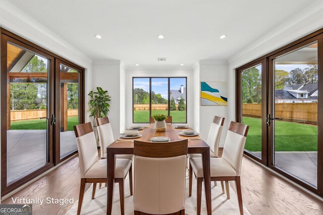 dining space featuring crown molding, french doors, wood finished floors, and visible vents