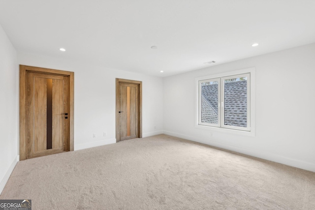 carpeted spare room featuring visible vents, baseboards, and recessed lighting