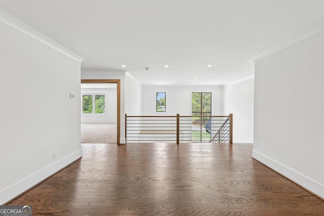 empty room with a wealth of natural light, baseboards, and crown molding