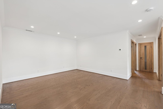 unfurnished room featuring crown molding, visible vents, recessed lighting, wood finished floors, and baseboards