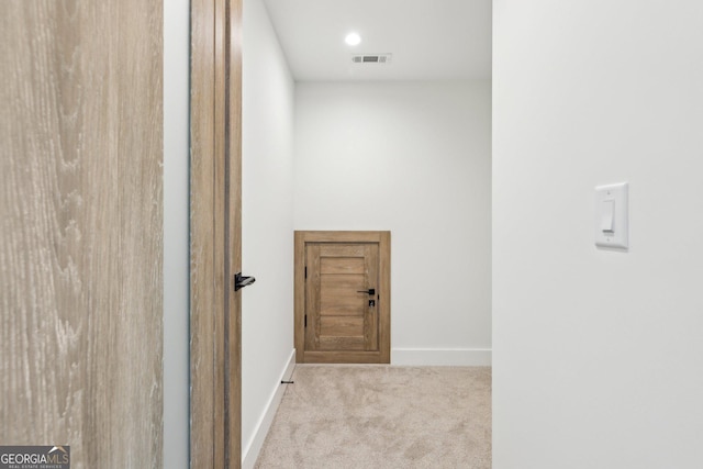 corridor with visible vents, baseboards, and carpet