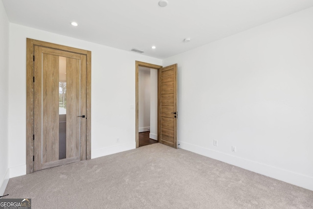 unfurnished bedroom with baseboards, carpet, visible vents, and recessed lighting