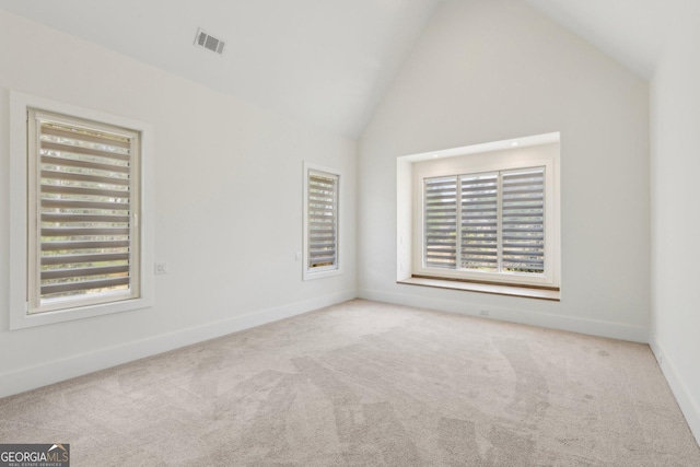 carpeted spare room with high vaulted ceiling, baseboards, and visible vents